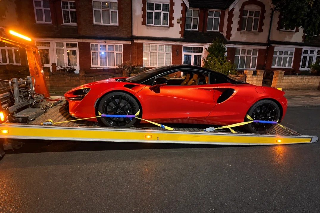 Red Supercar on Amber-Lit Tow Truck